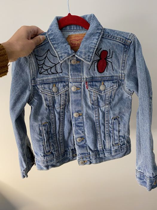 Kids denim jacket with an embroidered spiderweb and red spider on the front