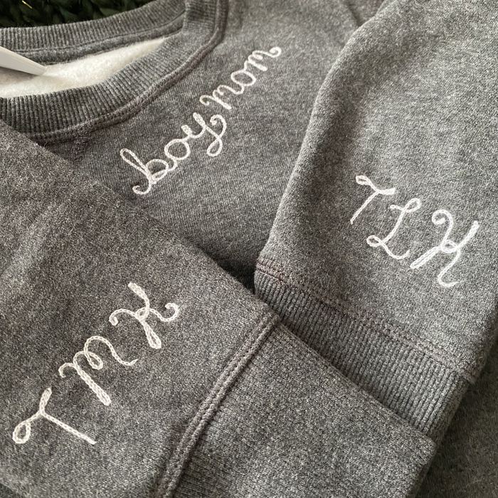 Gray sweatshirt sleeves embroidered with initials and boy mom in white chainstitch
