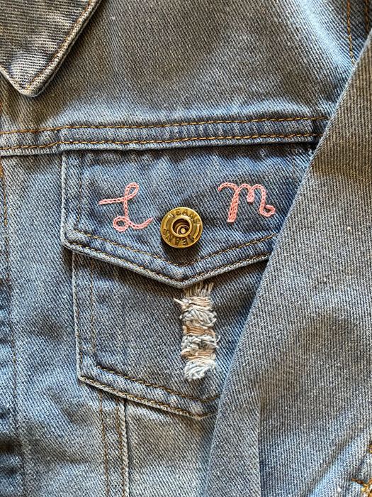 Denim jacket pocket with chainstitch initials L and M
