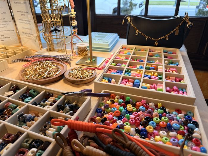 Charm trays and chunky letter beads laid out at a charm bar party