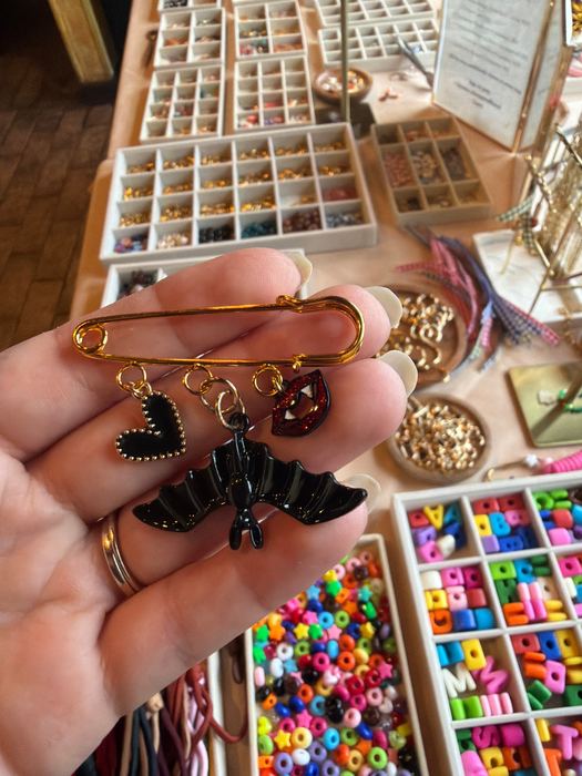 Safety pin brooch with heart, bat and vampire lips charms