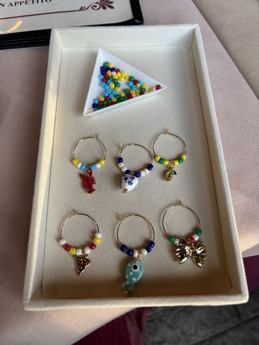 Wine glass charms with seed beads and enamel charms in a tray