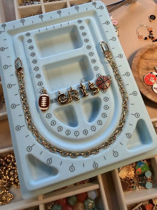 Bag chain with letter charms and a football charm on a bead board