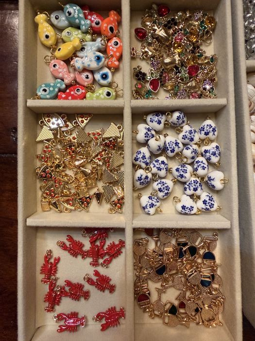 Tray of charms including evil eyes, porcelain hearts and red lobsters