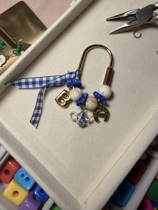 Blue gingham carabiner keychain with a letter B, teapot and horseshoe charms