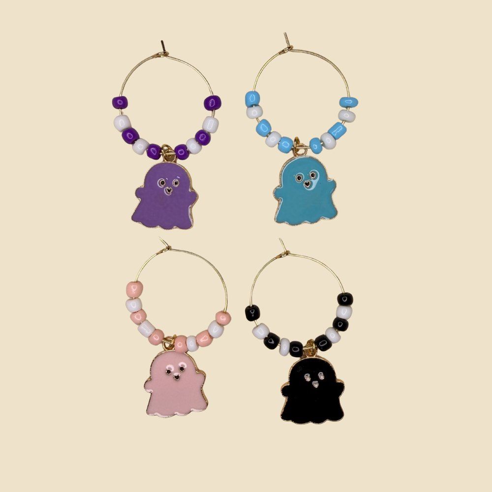 Set of four beaded stainless steel wine glass rings with enamel ghost charms in purple, blue, pink and black