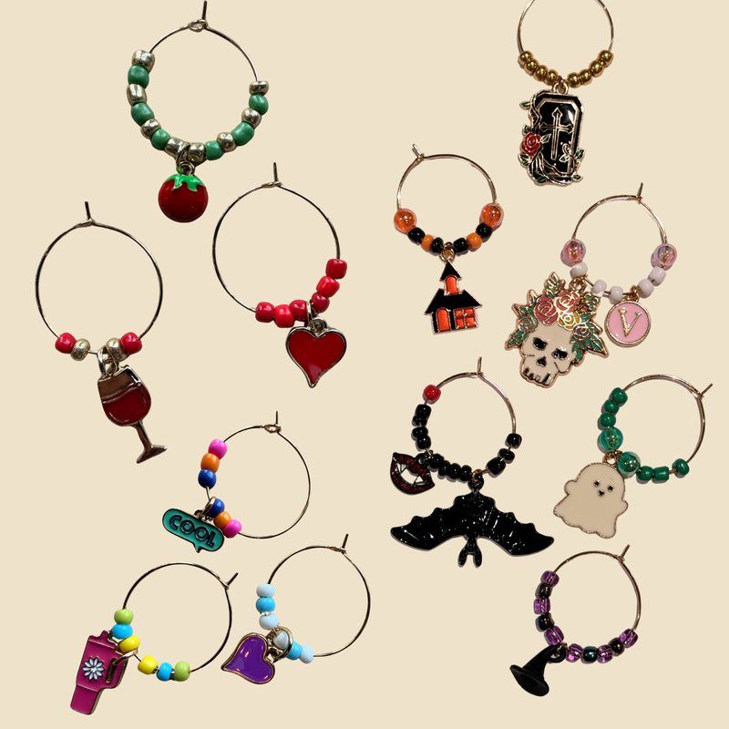 Assorted wine glass charm rings with seed beads and enamel charms, including a tomato, hearts, a ghost, a bat and a skull